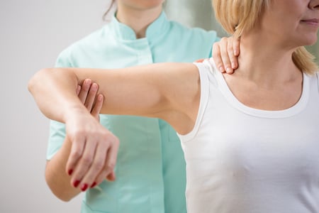 Physical therapist diagnosing patient with painful arm-1