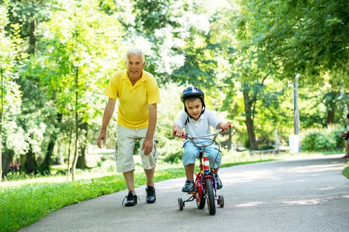 happy grandfather and child have fun and play in park on beautiful  sunny day